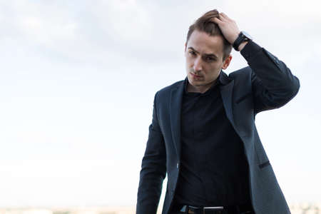 young guy in a suit straightens hairの写真素材