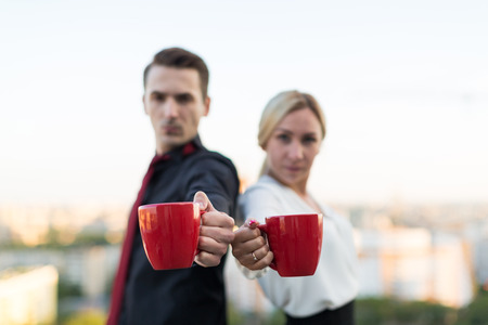 man and woman with cups on the background the cityの写真素材