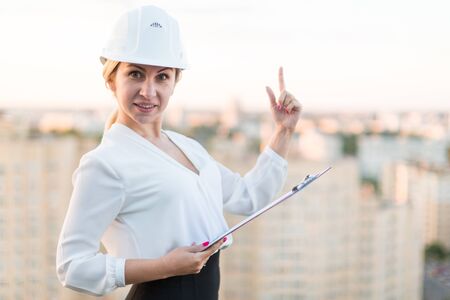 Girl builder with folder standing against the background of the cityの写真素材