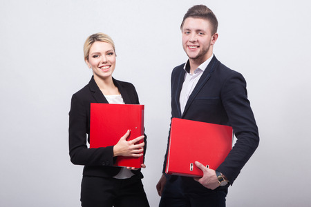 two businessmen the man and woman with red office folders on a white background.の写真素材