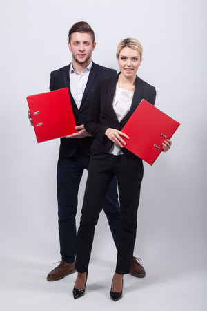 two businessmen the man and woman with red office folders on a white background.の写真素材