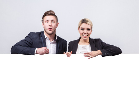 studio portrait on white background of successful business men and women in business suits next to the board for advertising which could be your textの写真素材