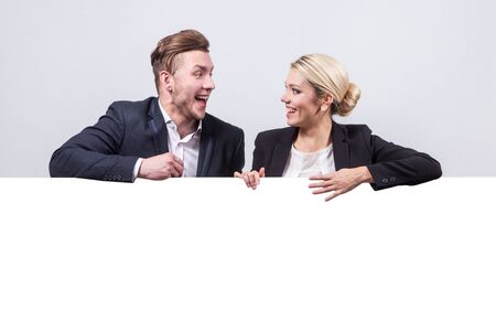 studio portrait on white background of successful business men and women in business suits next to the board for advertising which could be your textの写真素材