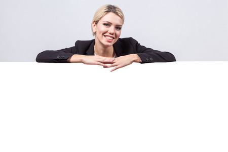 studio portrait on white background successful business woman in a business suit with a board for a number of advertising which could be your textの写真素材