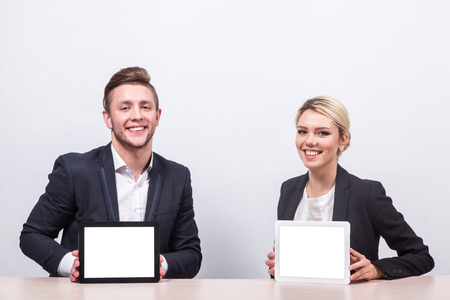 man and woman business people sitting at the table and looking at the camera with smilesの写真素材