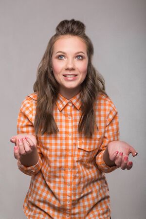 portrait energetic cheerful student girl on gray background in a denim shirt with a broad smile on his face and bright emotionsの写真素材