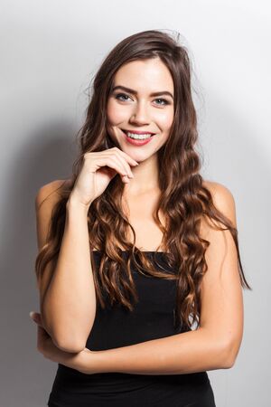 young beautiful stylish girl in a black business dress and sunglasses standing on a white background with a snow-white smile, smiling, picture with depth of field,の写真素材