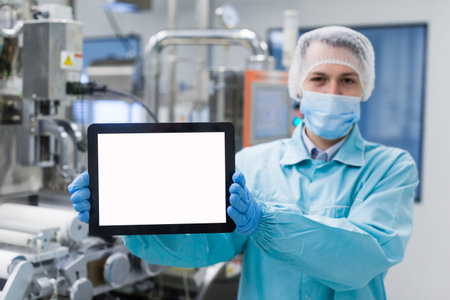 blured background, caucasian scientist man in blue lab uniform stand near manufacture machine with...