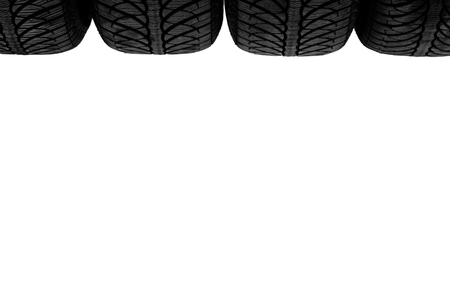 Isolated on white, four tops of new black rubber automobile tires with protector, closeup, position on bottomの写真素材