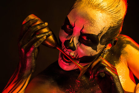 Isolated on black, closeup picture, toned red and yellow, beautiful young blonde caucasian woman...