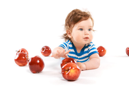 a newborn surrounded by apples on white backgroundの写真素材