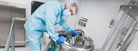 widescreen picture, caucasian scientist in blue lab suit and gloves configure pressure on big steel...