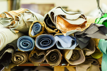 rolls of fabric wrapped in craft paper lying on each other. manufacture. close-up photo