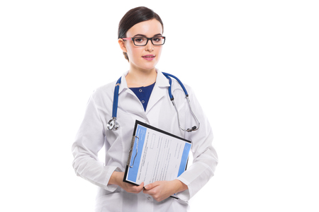Portrait of young attractive female doctor in white coat standing in office and looking in camera confident friendly experienced skilful positive cheerful smiling happy brunette caucasian beautiful pretty gp with glasses.の写真素材
