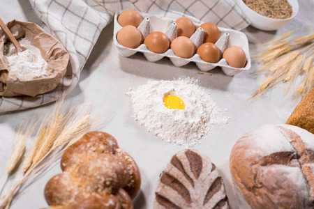 Top view of dough ingredients for cooking and loaves of bread on kitchen table isolated on grey backround home-bakery concept.の写真素材
