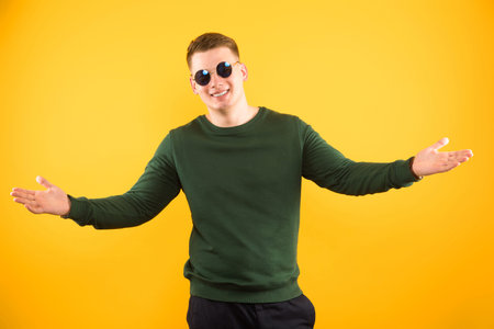 Caucasian confident smart funny friendly young man in sweater standing in office looking in camera showing signの写真素材