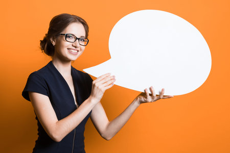 Caucasian brunette smiling attractive businesswoman in formal suit holding speech bubble in her...