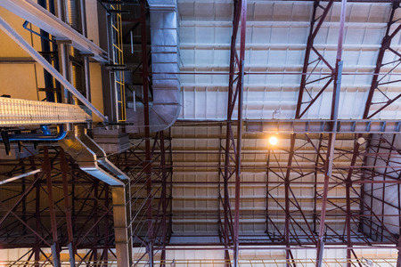 Down up view of modern operational plant with grey pipes heavy industry machinery metalworking workshop concept.の写真素材