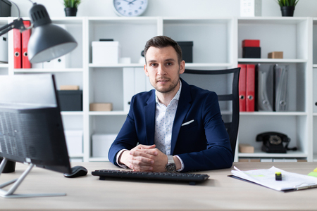 A young man in a blue business suit and in a light shirt. A handsome young man with a stubble on his face. photo with depth of fieldの写真素材