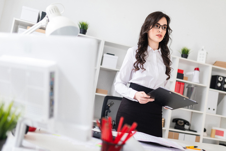 A charming young girl is working in a bright office. photo with depth of field.の写真素材