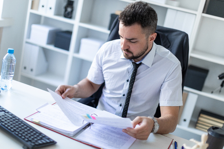 A bearded man with a business suit is working in a bright office. photo with depth of field.の写真素材