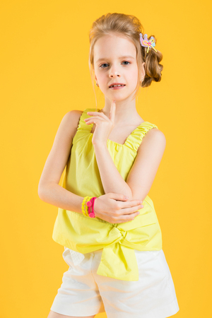 Portrait of a teenage girl in a yellow T-shirt and white shorts.の写真素材