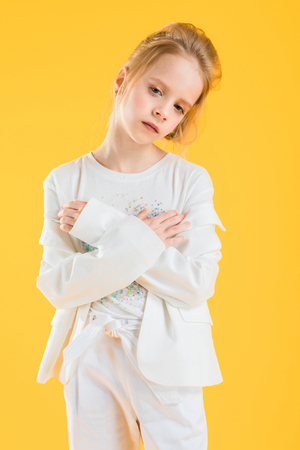 Portrait of a teenage girl in a white suit and a white T-shirt with a heart.の写真素材