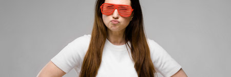 Portrait of plus size model with long hair wearing white blank T-shirt and stylish sunglasses...