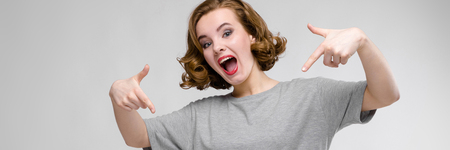 Beautiful young girl posing on gray background.の写真素材