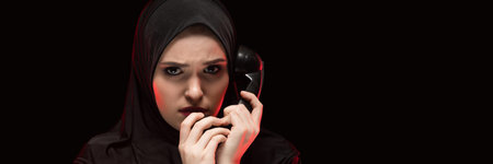 Attractive confident serious upset desperate muslim arabian woman dressed in black hijab standing in...