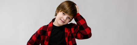 Portrait of small adorable thoughtful stylish confident caucasian guy standing in studio looking in...
