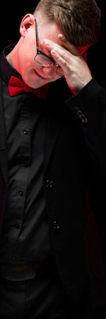 Young caucasian elegant serious smart successful business man in black suit with bow-tie standing in...