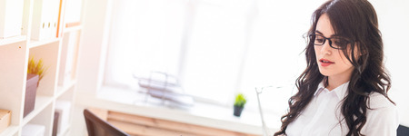 A charming young girl is working in a bright office. photo with depth of field.の写真素材