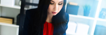 Portrait of a young girl in a suit. Beautiful girl is working in the office.の写真素材