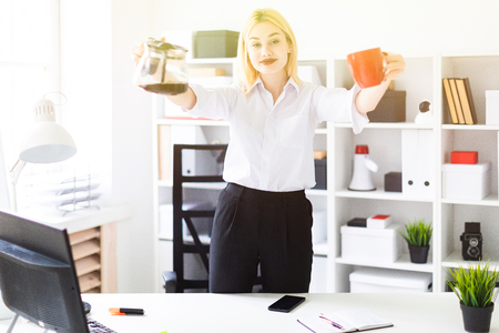 Cute young girl working in a bright office. The girl has white hair and wearing glasses. Shes wearing a white shirt and black pants. photo with depth of fieldの写真素材