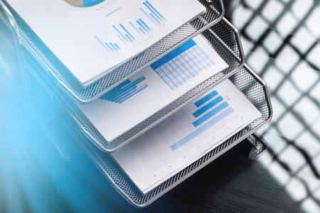 Business documents with graphs and diagrams are on bookcase. Can be used as business background....
