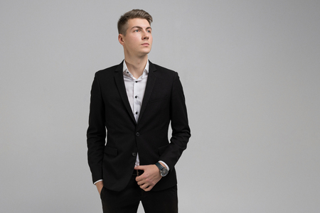 Young businessman full length full length portrait. business young man in an official suit stands alone in bright Studioの写真素材