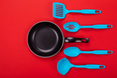 Close-up picture of frying pan with spatula and spoon as kitchen utensils for cooking conceptの写真素材