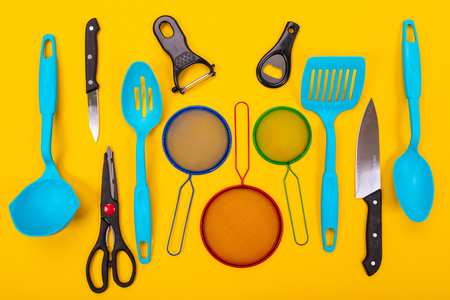 Composition of kitchen utensils for cooking isolated on colorful yellow backgroundの写真素材