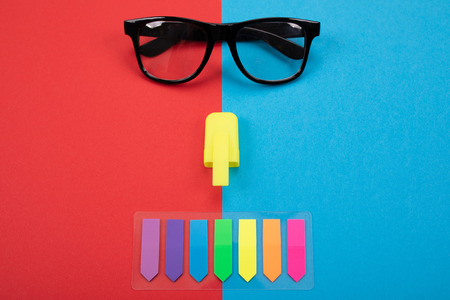 Picture of glasses and stickers isolated on blue and red background as business style conceptの写真素材