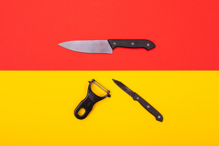 Kitchen knife on a red background and a flosser with a small knife under it on a yellow background. Can be used as a background in the food industry. Stylish menu design for the restaurantの写真素材