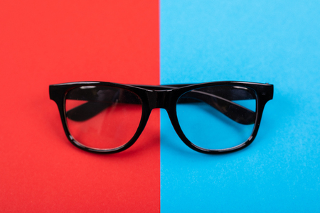 Picture of glasses isolated on blue and red background as business style conceptの写真素材