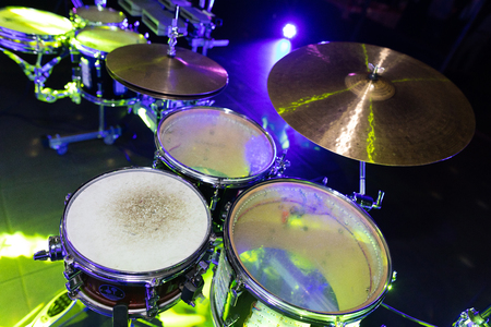 Drum set in the light of night lights in the night club. Close-up of three drums. Disco at the eventの写真素材