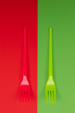 Bright green and red forks atop of red and green background. Mock-upの写真素材