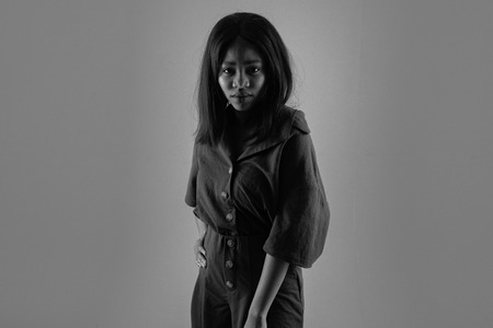 Young beautiful african american girl posing in red sensual dress over dark background. Girl with afro and glamour makeup. Studio shotの写真素材