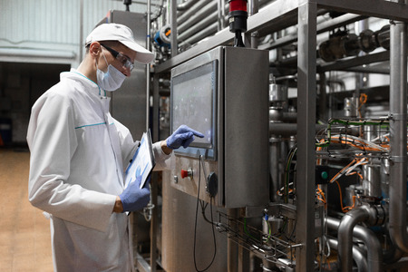 technologist make set up of the production line while standing near digital screen at the department...