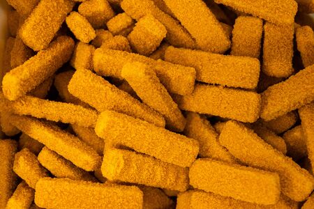 Bunch of bright orange delicious fish sticks or fish fingers for traditional English meal. Close-up, flatlayの写真素材