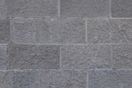 Front view of grey brick wall texture background. Tiled concrete cement surface