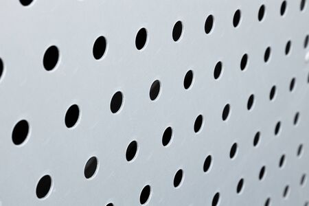 Rapid black big dot pattern on white background, round holes texture on perforated metal panel surfaceの写真素材
