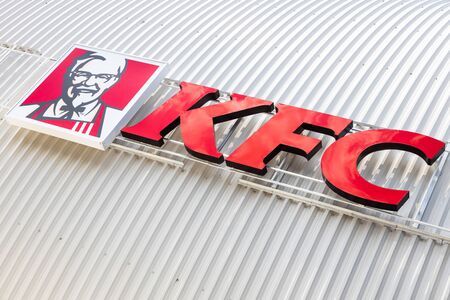 Minsk, Belarus - July 20, 2019: KFC fast food restaurant logo on white gugate facade background,...